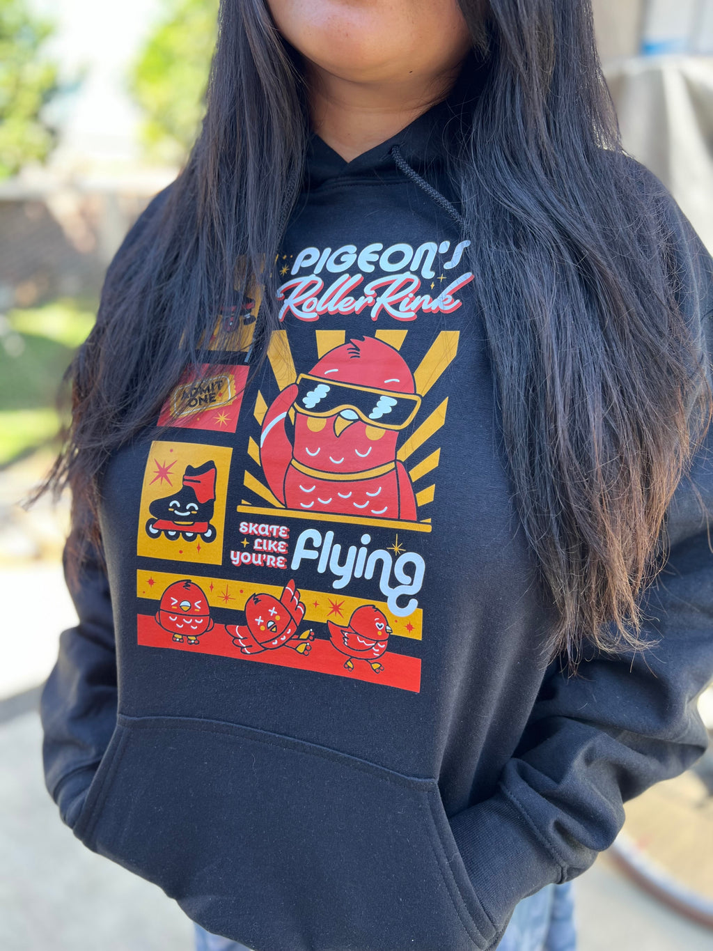 Person wearing black hoodie with orange pigeon print 
