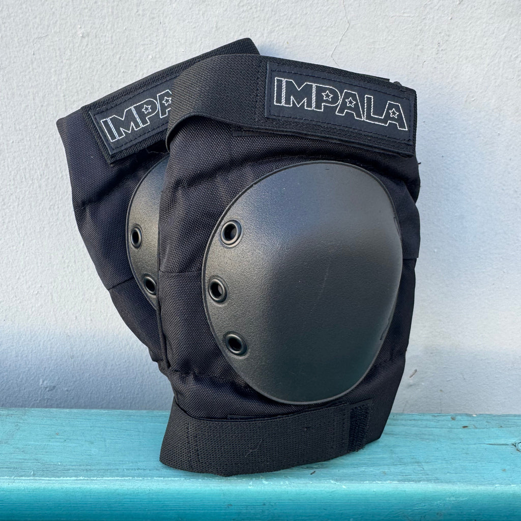 Black knee pad with IMPALA branding on a light blue and white background